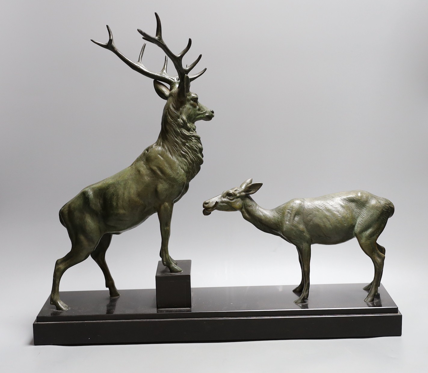 A French bronzed metal model of a stag and deer on a black marble base, signed L. Carvin, 43 cms high